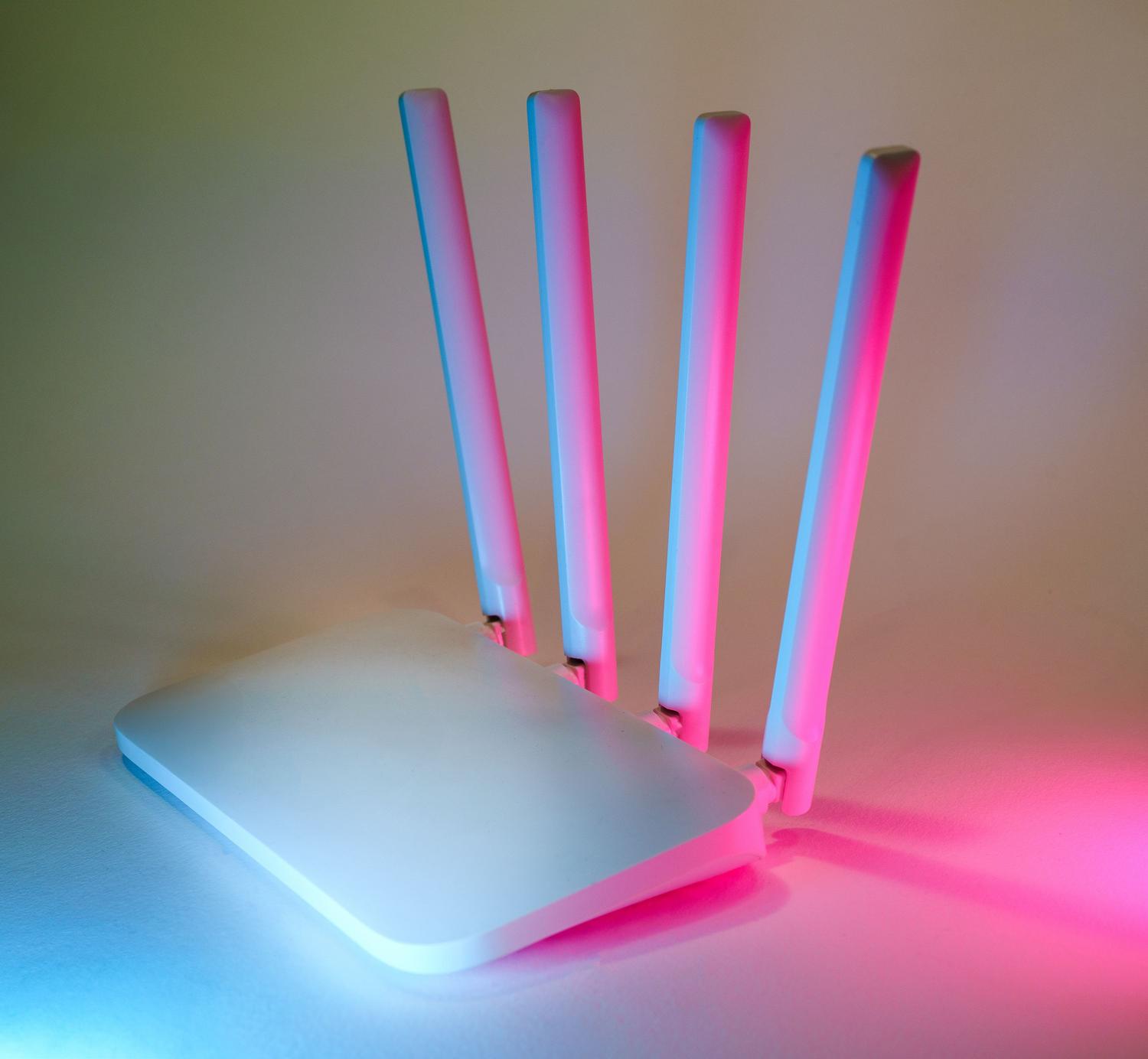 Primer plano de un router de alta gama con iluminación neón, simbolizando la alta velocidad y el rendimiento del estándar WiFi 7 Primer plano de un router de alta gama con iluminación neón, simbolizando la alta velocidad y el rendimiento del estándar WiFi 7