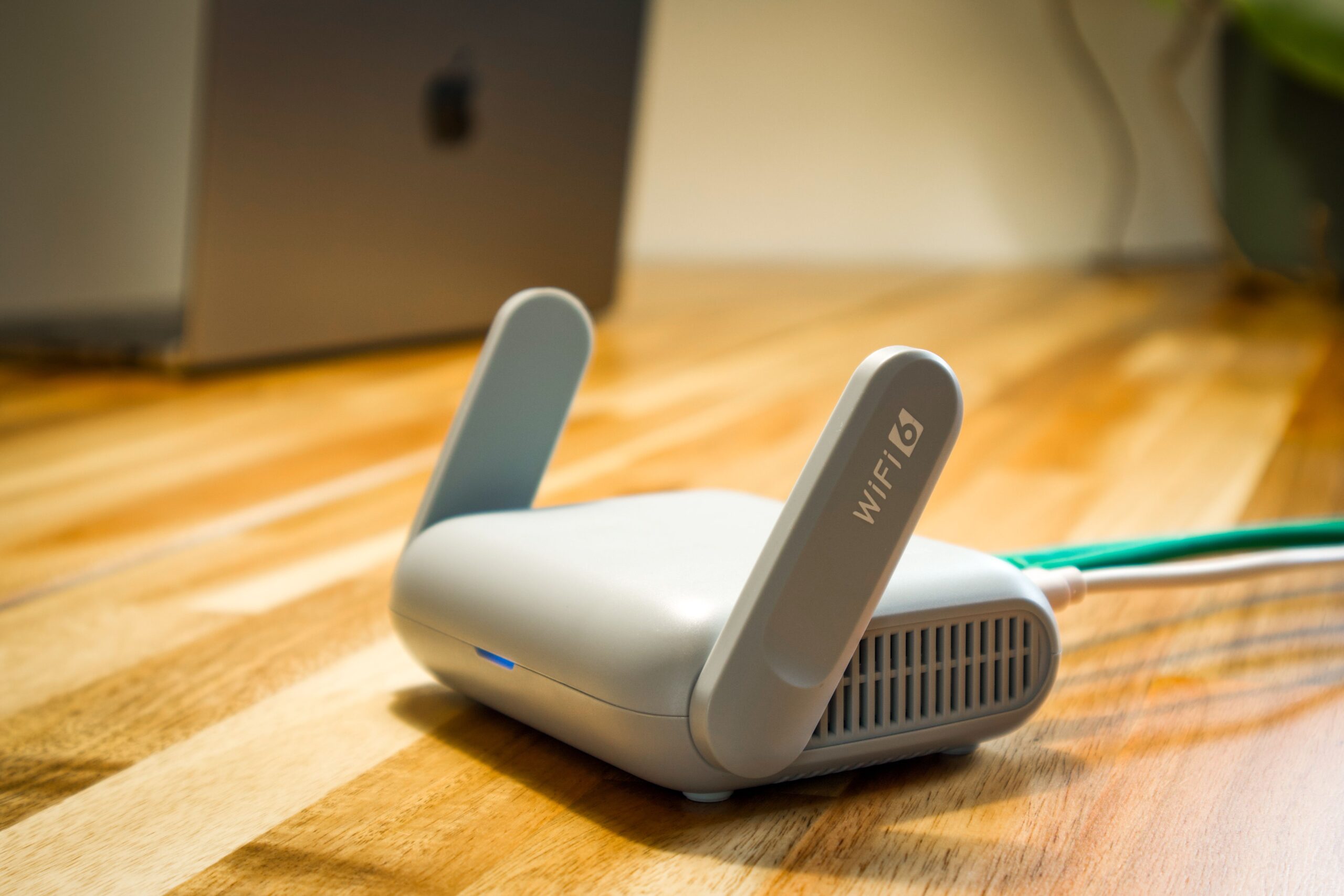Primer plano de un router WiFi 6 sobre un escritorio de madera, simbolizando la alta velocidad y los estándares de conexión más modernos. Primer plano de un router WiFi 6 sobre un escritorio de madera, simbolizando la alta velocidad y los estándares de conexión más modernos.