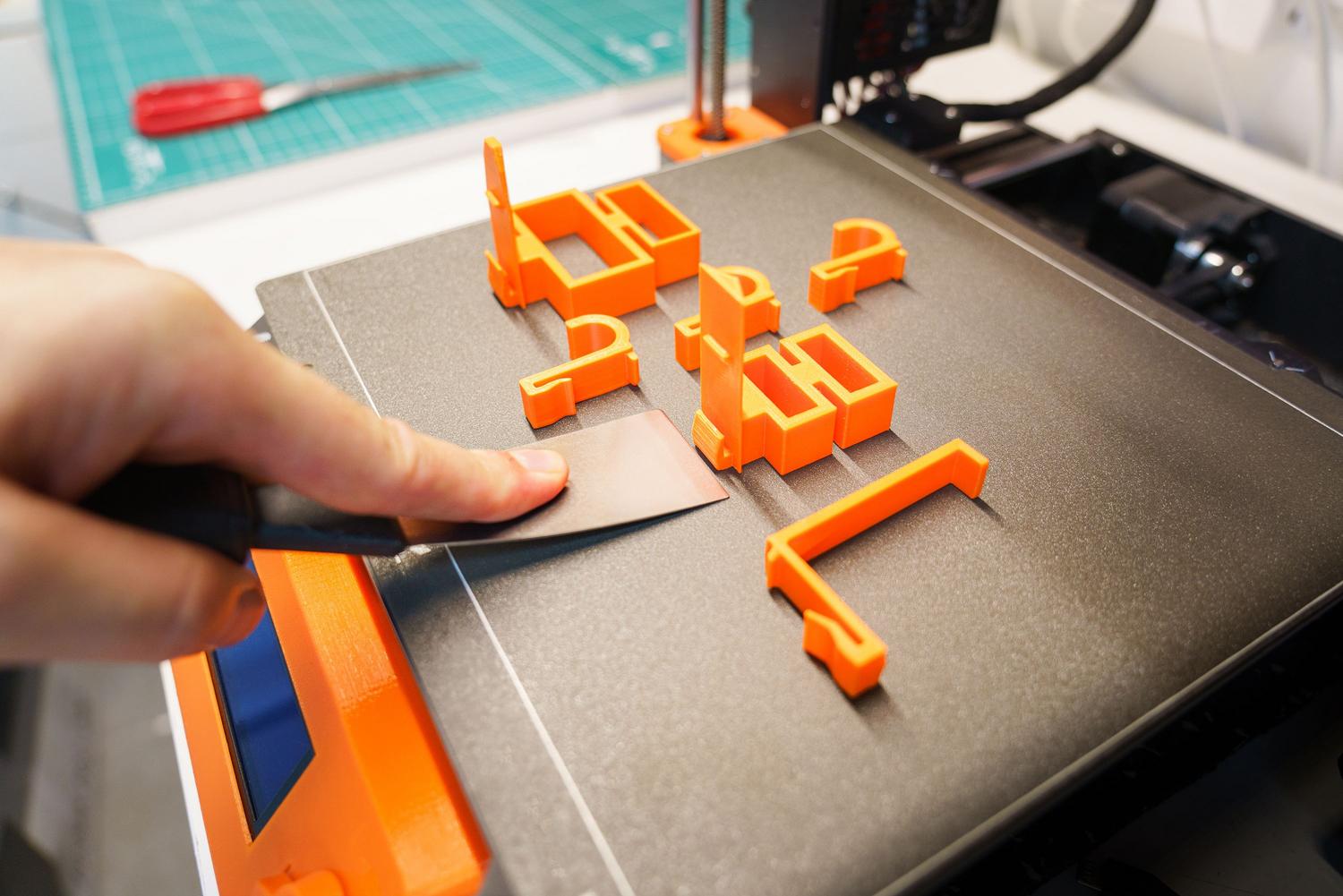 Proceso de retirada de una pieza técnica impresa en 3D utilizando herramientas de precisión. Proceso de retirada de una pieza técnica impresa en 3D utilizando herramientas de precisión.