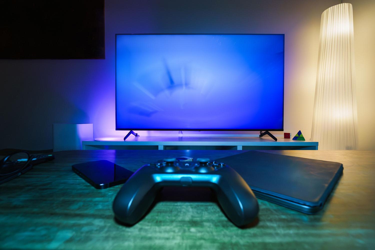 Configuración de gaming moderna con consola, mando y luz ambiental para una experiencia inmersiva en OLED Configuración de gaming moderna con consola, mando y luz ambiental para una experiencia inmersiva en OLED