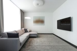 Salón moderno y minimalista con un televisor OLED de diseño delgado montado en la pared
